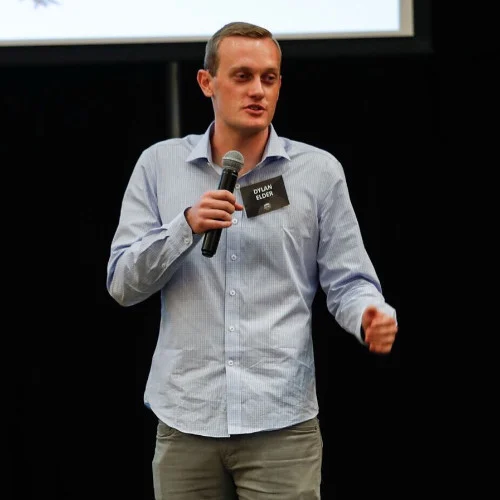 Dylan Elder speaking into a handheld microphone